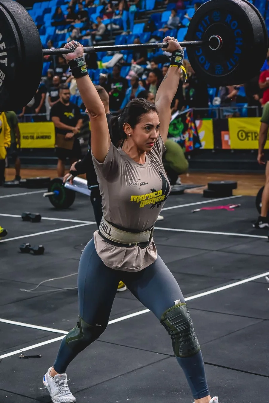 Atleta realizando split jerk com barra durante competição