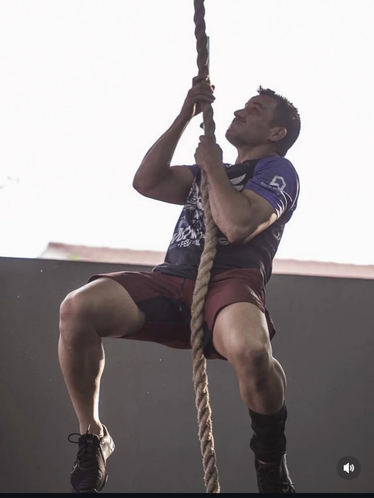 Atleta subindo na corda durante uma prova