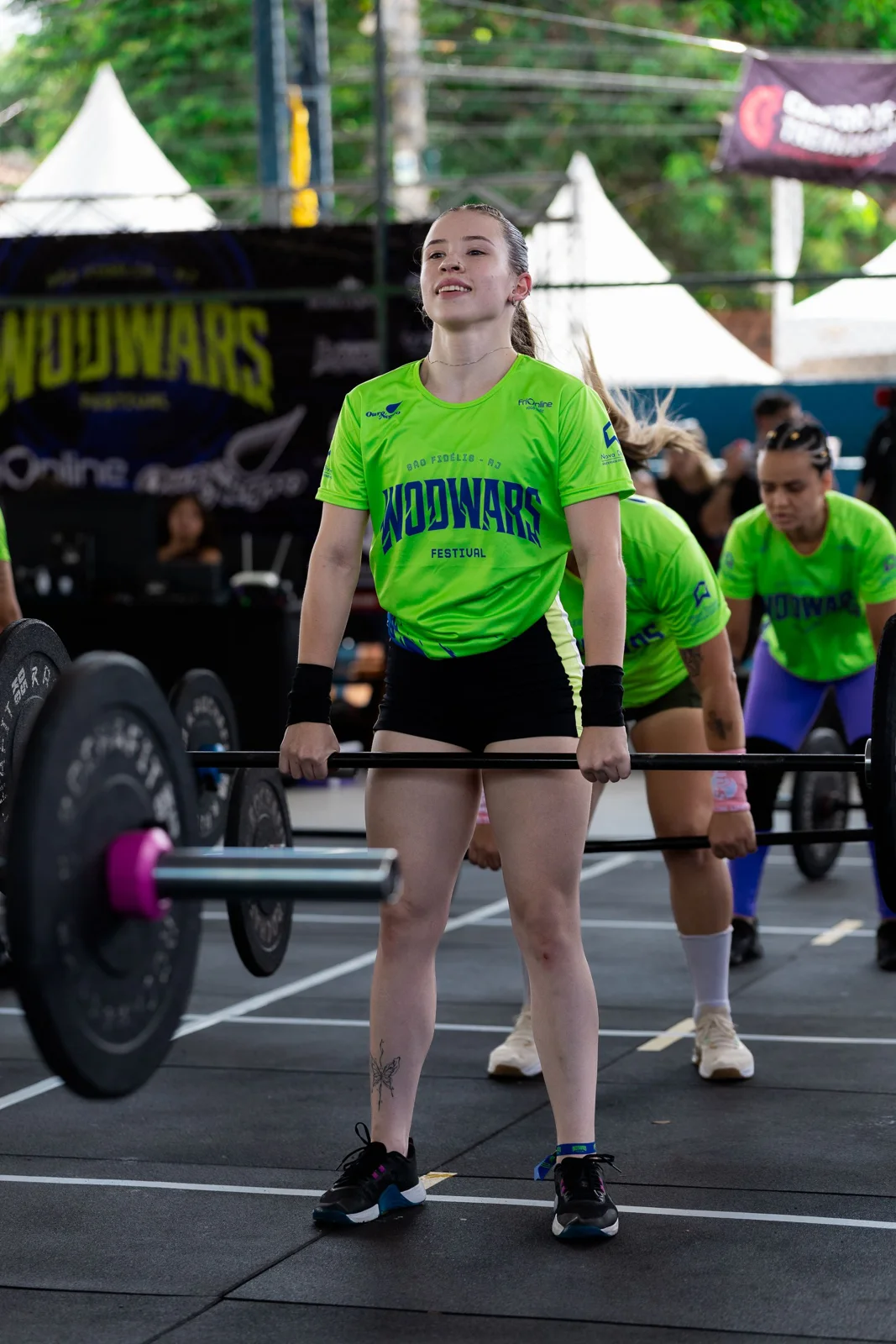 Atleta executando levantamento com barra durante uma prova do WOD WARS