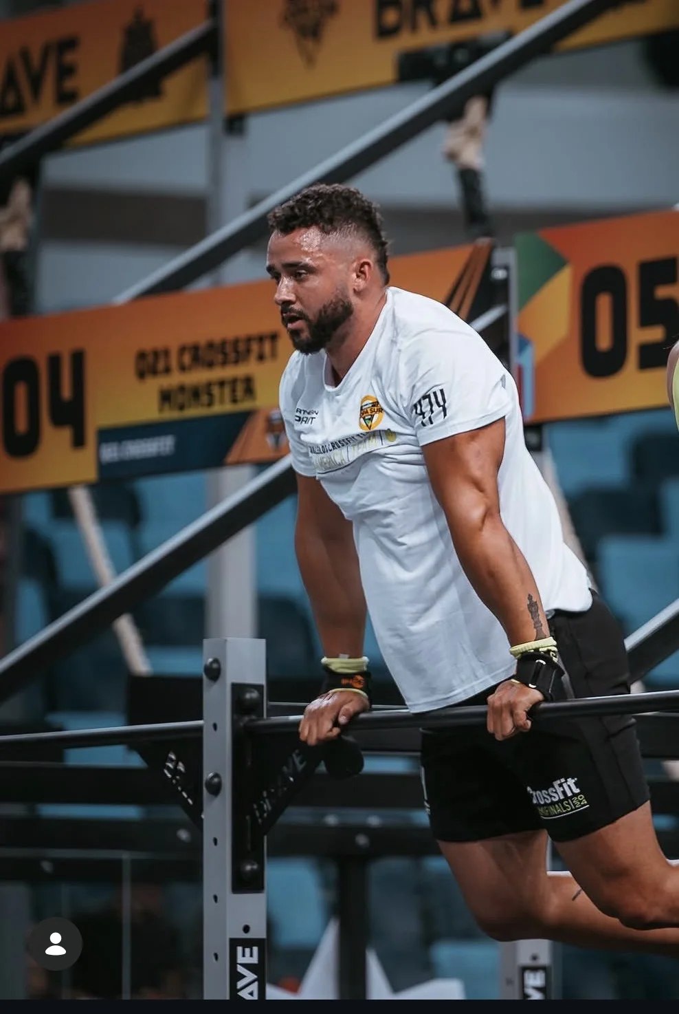 Atleta em apoio na barra durante execução de ginástica