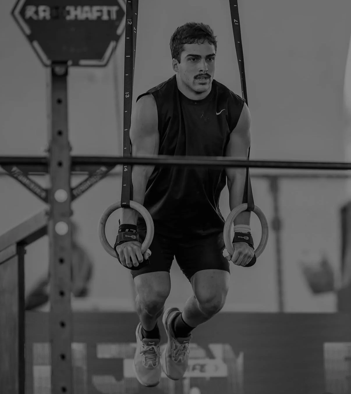 Atleta em posição de apoio nas argolas durante treinamento de ginástica